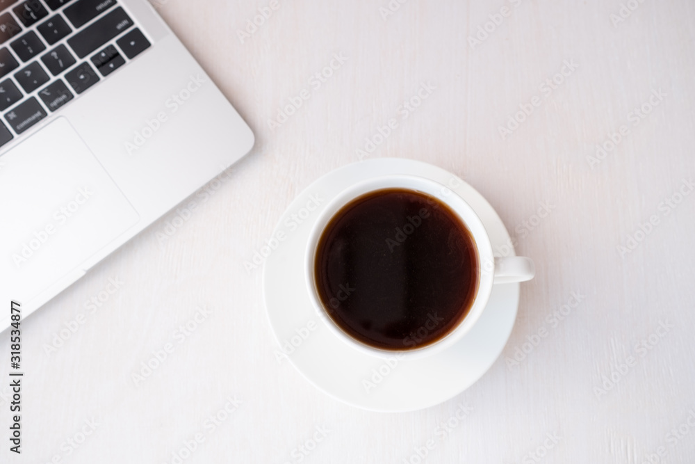 Cup of coffee from a laptop computer with fresh croissants. on white background.concept of education Cup of coffee from a laptop computer with fresh croissants. on white background.concept of education