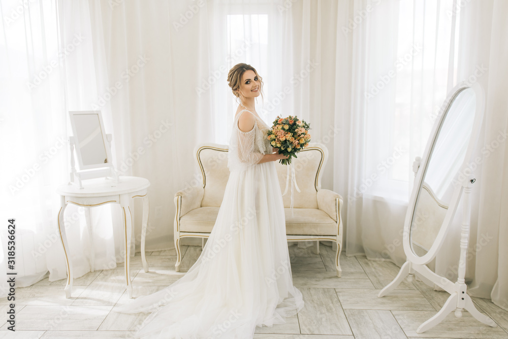 Portrait of a beautiful young bride in a bright room in a romantic atmosphere. Bride with a bouquet of flowers Portrait of a beautiful young bride in a bright room in a romantic atmosphere. Bride with a bouquet of flowers