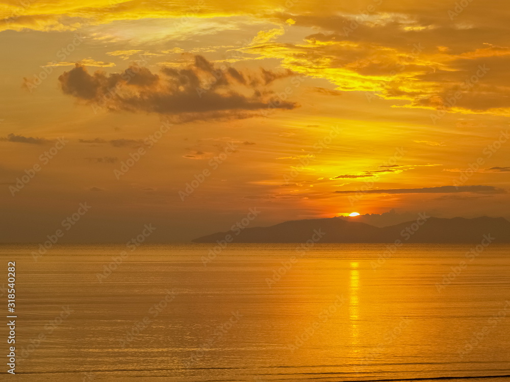 view seaside evening of golden sea with yellow sun light and cloudy sky background, sunset at Pak Meng Beach, Trang Province, southern of Thailand.