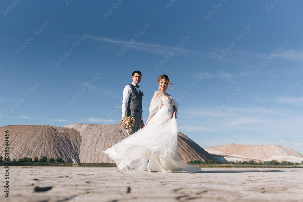 Beautiful elegant couple of newlyweds in love on a beautiful natural background of salt mountains and quarries Beautiful elegant couple of newlyweds in love on a beautiful natural background of salt mountains and quarries