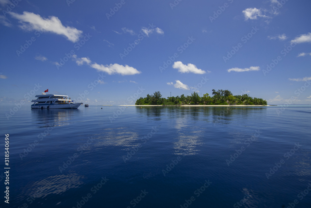 Motor boat on clear turquoise water... Maldives