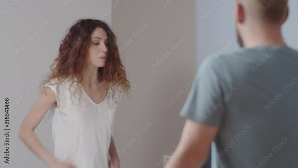 Waist-up shot of beautiful young Caucasian brunette woman in pajama swearing and abusing her husband before going to bed at night Waist-up shot of beautiful young Caucasian brunette woman in pajama swearing and abusing her husband before going to bed at night