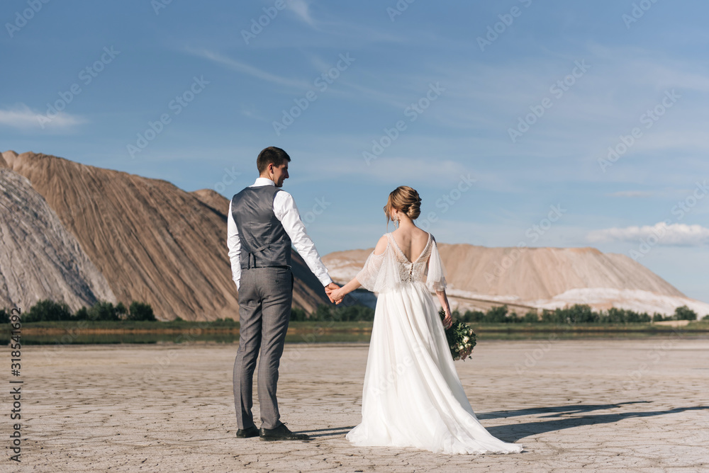 Beautiful elegant couple of newlyweds in love on a beautiful natural background of salt mountains and quarries Beautiful elegant couple of newlyweds in love on a beautiful natural background of salt mountains and quarries