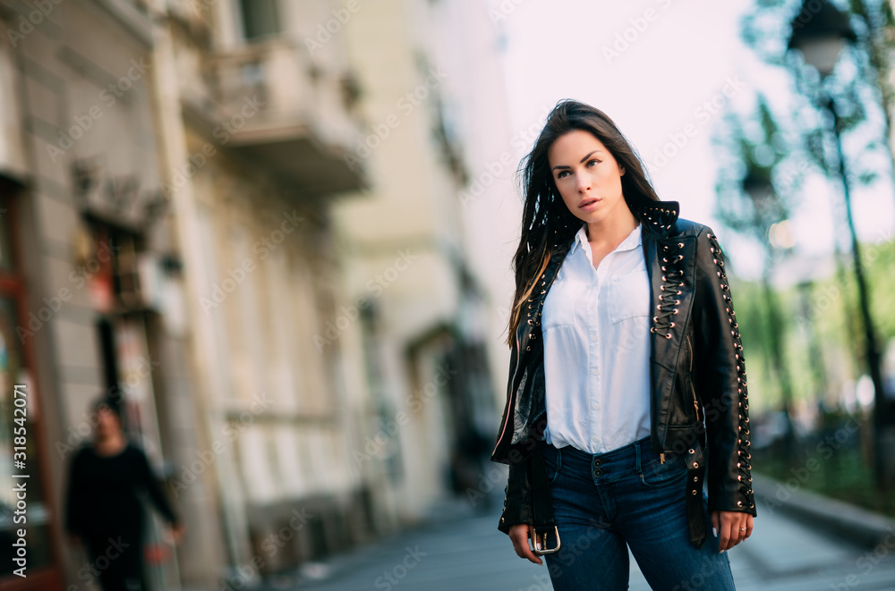 Beautiful fashion model in black leather jacket posing outdoor. Beautiful fashion model in black leather jacket posing outdoor.