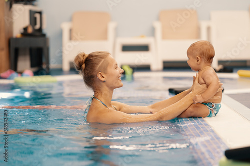 Mother and little son having fun in a swimming pool
