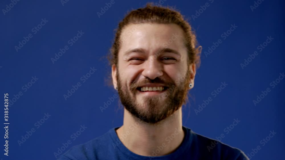 Young attractive bearded hipster smiling, laughing and looking at camera. Young attractive bearded hipster smiling, laughing and looking at camera.