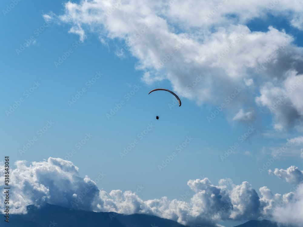 Paraglider flying far in the sky against the background of clouds Paraglider flying far in the sky against the background of clouds
