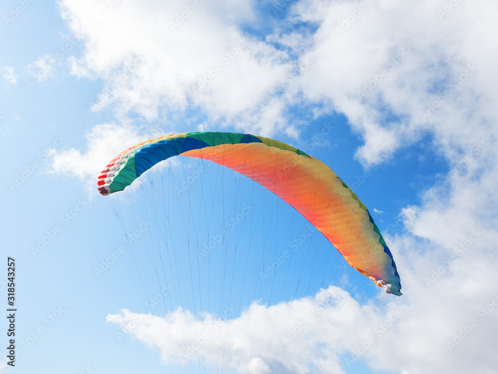 The dome of the paraglider with slings against the blue sky and clouds The dome of the paraglider with slings against the blue sky and clouds