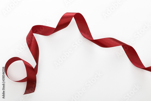 top view of satin burgundy decorative curved ribbon isolated on white