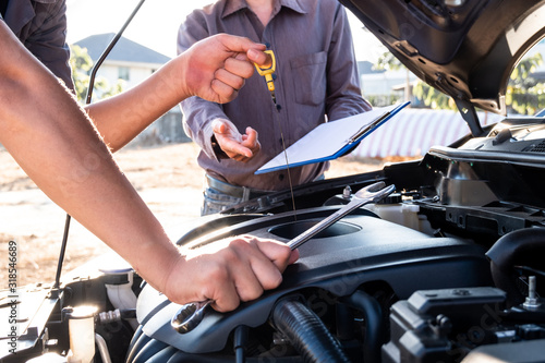 Repairman and insurance agent Checking engine order using modern tools
