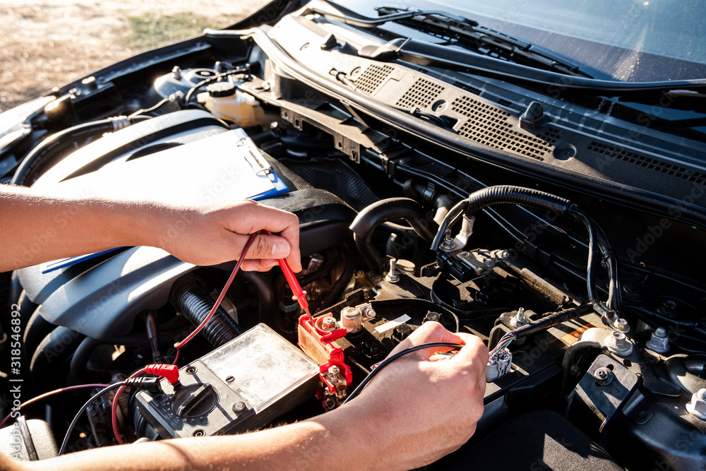 The hands of the repairman are checking the order of the engine using modern tools The hands of the repairman are checking the order of the engine using modern tools