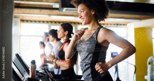 Group of young people exercising on a treadmill at gym
