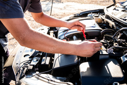 The hands of the repairman are checking the order of the engine using modern tools