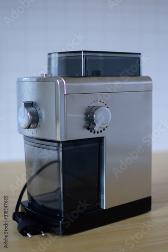 An electric coffee grinder is standing on the kitchen table.