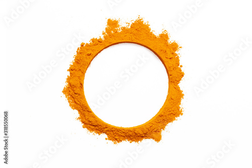 Orange turmeric powder is scattered on a white background. Natural, useful healing spice from the East. Turmeric photo