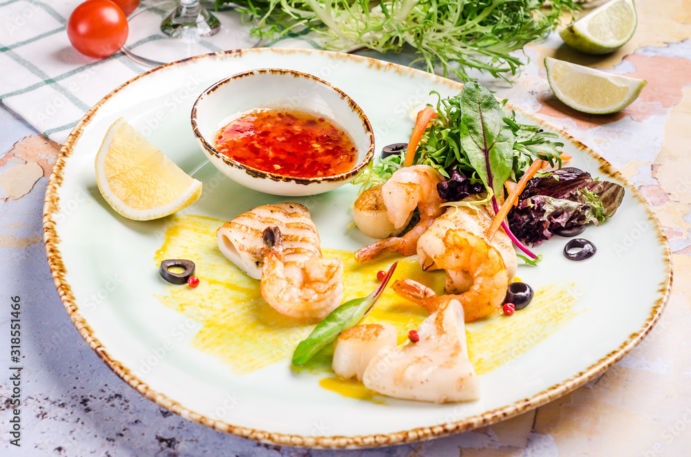 Closeup of grilled shrimp with red chili pepper sauce, vegetables at a table background. Closeup of grilled shrimp with red chili pepper sauce, vegetables at a table background.