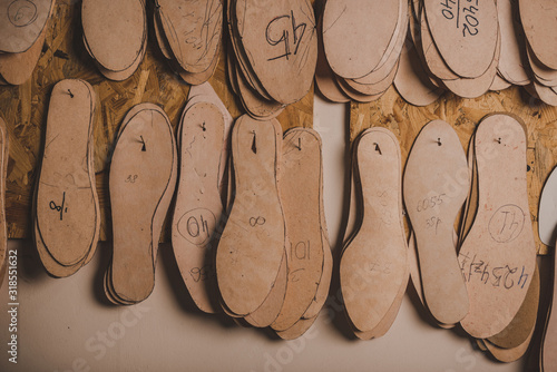 Φωτογραφία footwear insoles of different sizes hanging on wall in workshop
