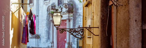 Street lamp and laundry in a picturesque narrow street of Alfama in the old town of Lisbon, Portugal
