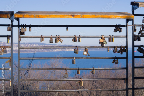 old metal locks hang on an iron fence