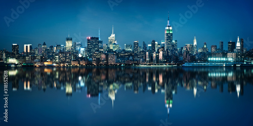 Panorama of the skyline of Manhattan viewed from Jersey city during the blue hour. New York skyline at night with reflections.