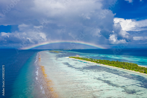 Fantastic aerial landscape in Maldives islands, stormy clouds with rainbow and amazing sea view