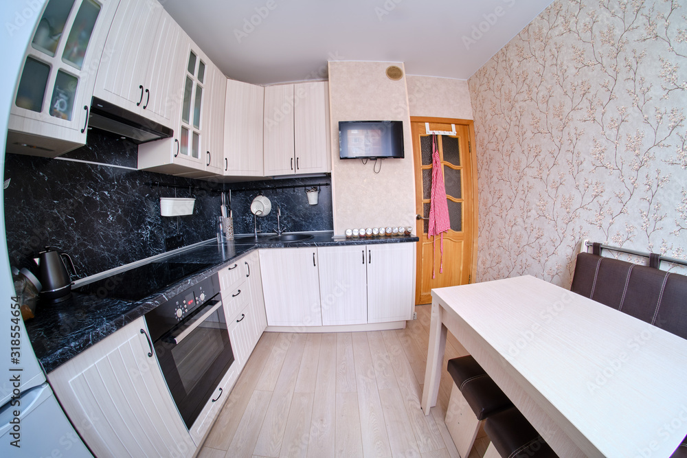 Fototapeta premium Modern black and white kitchen. High gloss kitchen with table and countertop (fisheye photo)