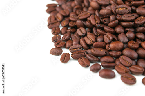 Dark coffee beans placed on a white scene.