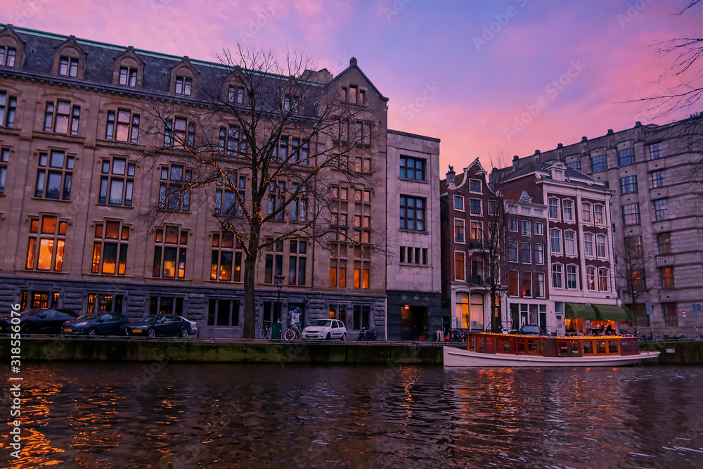 Traditional houses along the river Amstel in Amsterdam the Netherlands at sunset