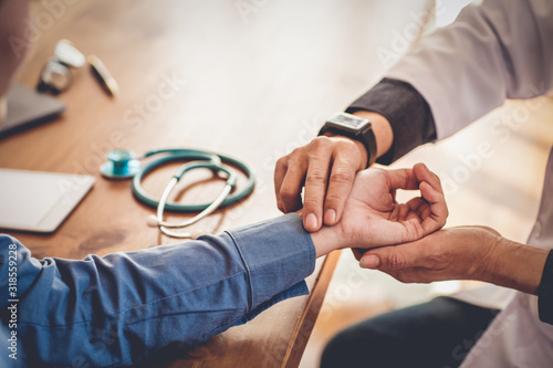 The doctor is checking the pulse for the patient.