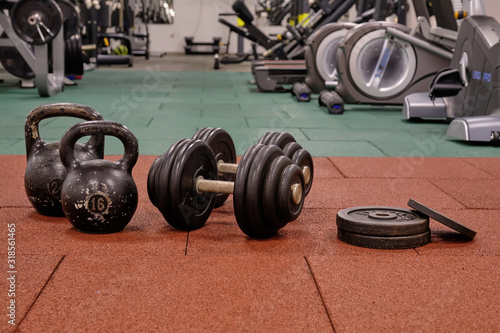 Dumbbells and kettlebells on the background of the gym. Bodybuilding equipment. Fitness or bodybuilding concept background.