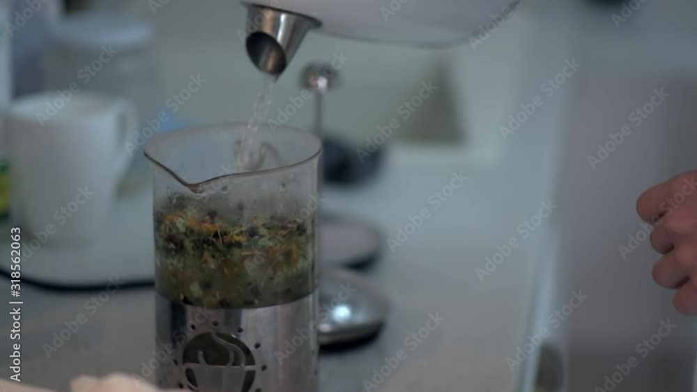 Adding natural herbs tea and hot water at the kitchen Adding natural herbs tea and hot water at the kitchen