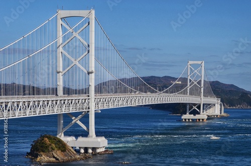 A ship passing through the wavy straits  Japan  Naruto Bridge 