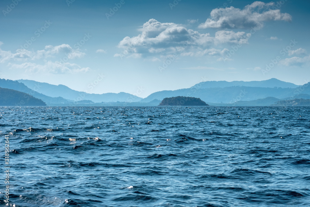 Blue ocean in Thailand with waves hill and haze