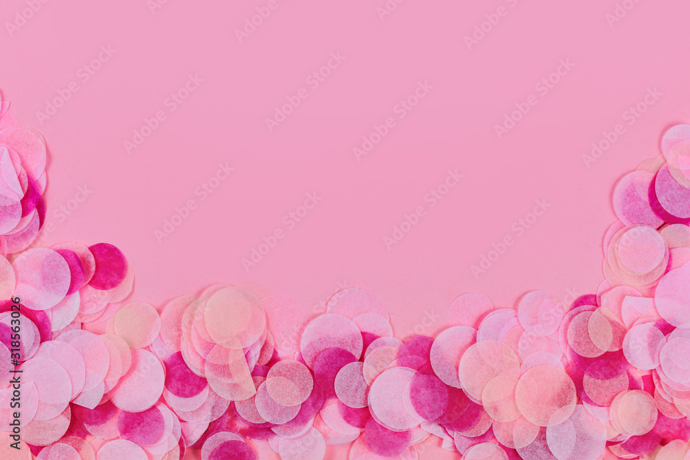 Pink party background with multicoloredpaper confetti at bottom border and copy space above