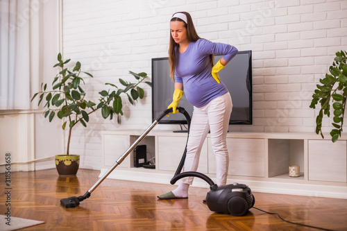 Wallpaper Mural Tired pregnant woman having pain in back while she is  cleaning her house. Torontodigital.ca