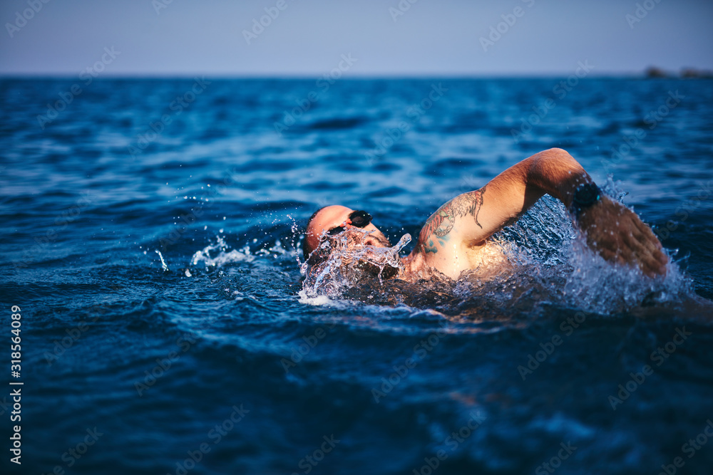 Swimmer training on the open sea / ocean.