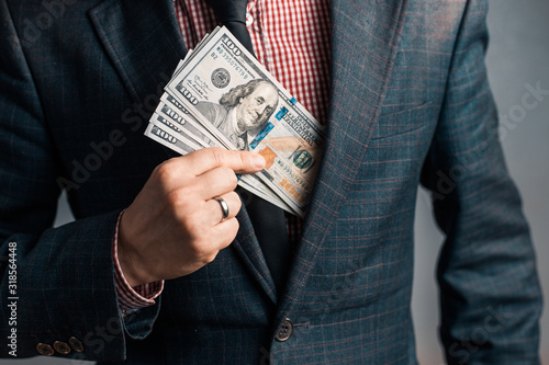 married businessman in suit hides Dollars