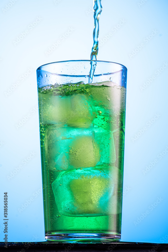misted glass with green carbonated drink tarragon and cubes of real ice misted glass with green carbonated drink tarragon and cubes of real ice