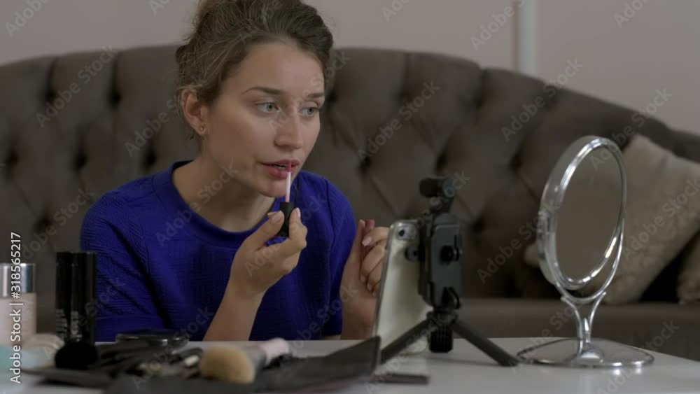 Woman vlogging on mobile phone, presenting and reviewing cosmetics accessories and products online Woman vlogging on mobile phone, presenting and reviewing cosmetics accessories and products online
