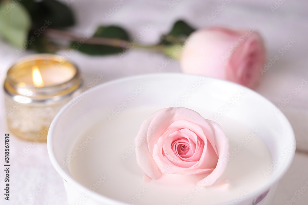 delicate pink rose in milk in the bathroom and a candle delicate pink rose in milk in the bathroom and a candle