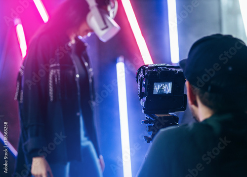 Slika na platnu The videographer is working in the dark studio with neon light