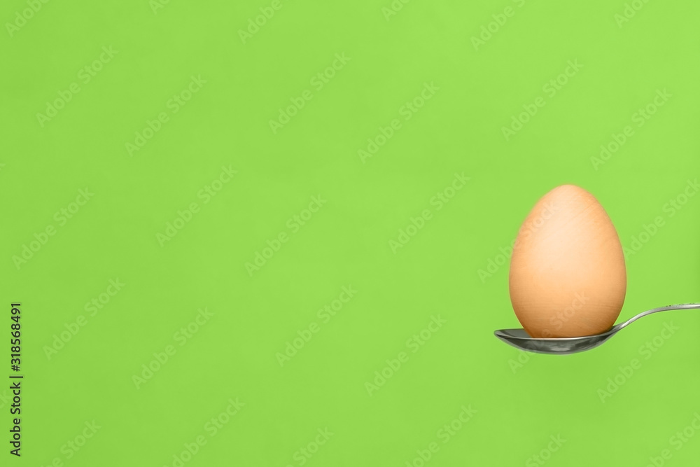 Egg on a spoon on a green background. Easter composition, copy space, flat lay, food. Egg on a spoon on a green background. Easter composition, copy space, flat lay, food.