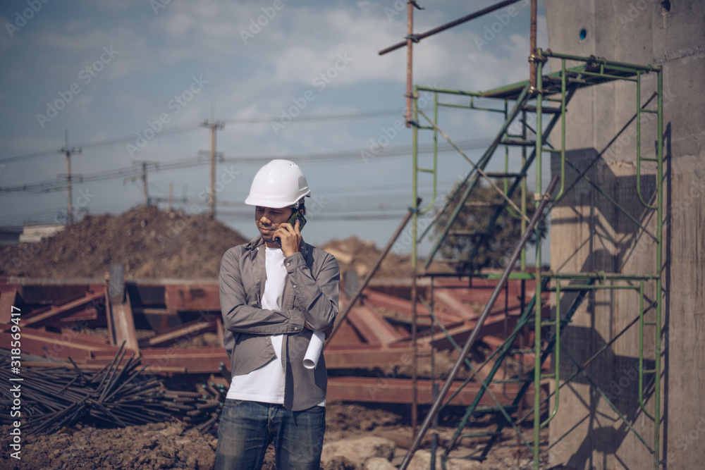 Asian engineer Talking phone in construction site, Construction Site Planning Concept