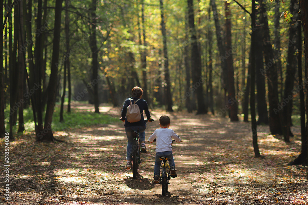 mother and her little son in forest in bycicle mother and her little son in forest in bycicle