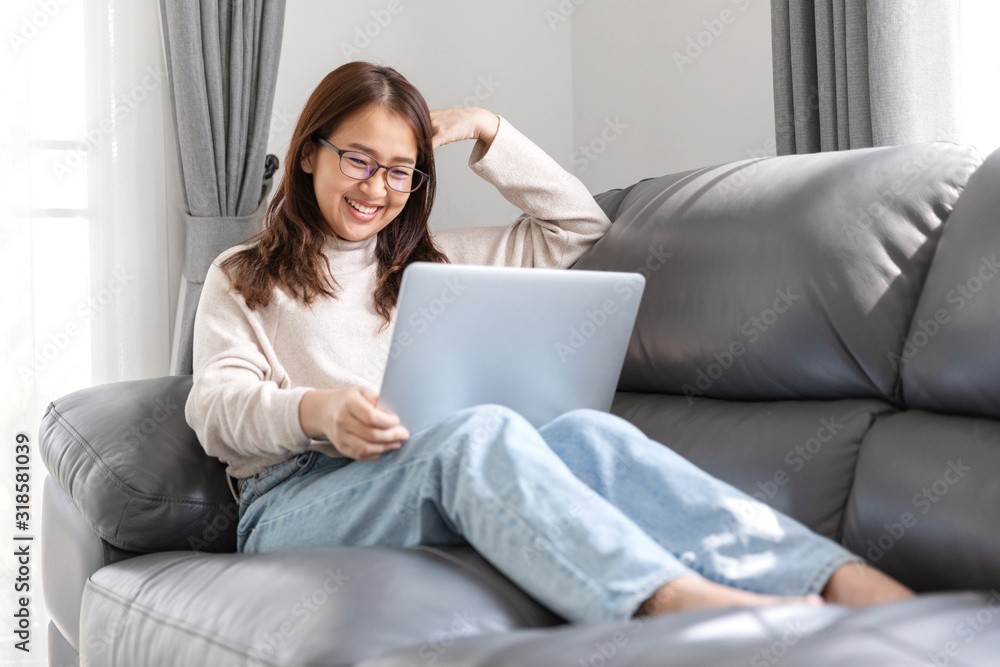 Young woman doing research work for her business, Smiling woman sitting on sofa relaxing while browsing online shopping website. Young woman doing research work for her business, Smiling woman sitting on sofa relaxing while browsing online shopping website.