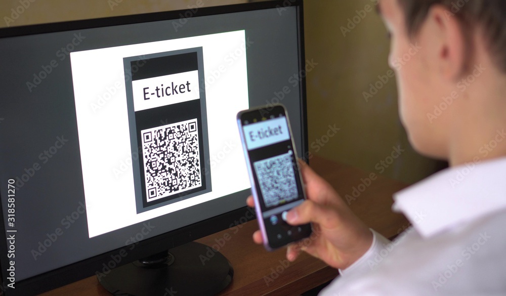A man purchases a E-Ticket with QR code online for the event, travel, trip. Electronic ticket booking, buying, payment A man purchases a E-Ticket with QR code online for the event, travel, trip. Electronic ticket booking, buying, payment