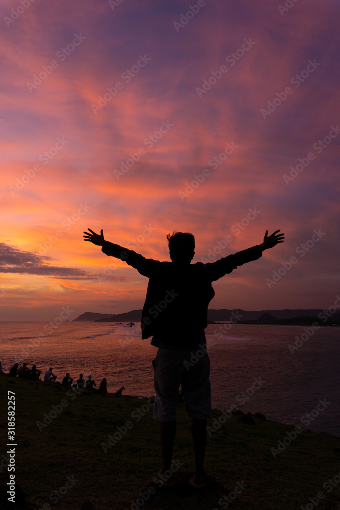 Fototapeta premium silhouette of Happy man at sunset