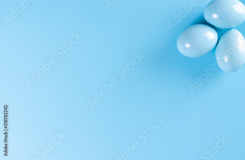 Easter eggs in pastel colors on pastel blue sky background. Copy space.