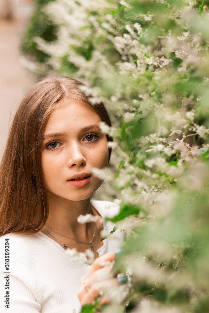 Happy young girl is enjoying flowering Happy young girl is enjoying flowering