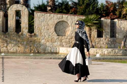 young muslim woman is walking in a modern city	
